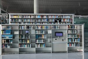 Prateleiras de biblioteca moderna com monitores integrados simbolizando a curadoria humana e tecnologia na escrita de e-mails.